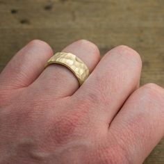 a person's hand with a gold ring on it