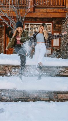 two young women are playing in the snow