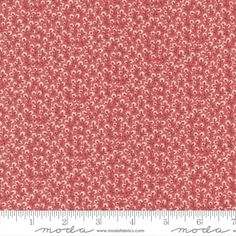 a red and white fabric with small flowers on it, as well as a ruler