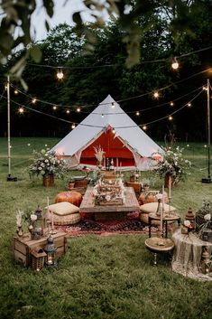 a tent set up in the middle of a field with tables and chairs around it