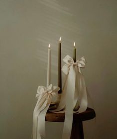 two candles with ribbons on top of them