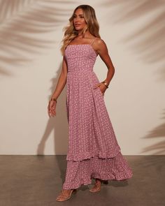 Step into summer sunset vibes with the Naiara Tiered Maxi Dress. Made from lightweight crepe fabric adorned with a charming floral print, this dress offers an effortlessly chic silhouette. The tiered design adds a touch of whimsy and movement, perfect for warm evenings and beachside gatherings. Embrace relaxed elegance and elevate your summer style with this breezy, sophisticated maxi dress. Square neckline Adjustable shoulder straps Side slant pockets Lightweight fabric Runs Large Hidden back z Summer Pink Tiered Skirt Dress, Summer Tiered Skirt Dress In Pink, Pink Tiered Skirt Summer Dress, Pink Feminine Tiered Maxi Dress, Pink Feminine Tiered Beach Dress, Pink Maxi Dress For Summer Outings, Pink Tiered Sundress For Beach, Feminine Tiered Maxi Dress For Beach, Feminine Pink Tiered Maxi Dress