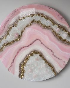 a pink and white plate with gold glitters on the edges, sitting on a table