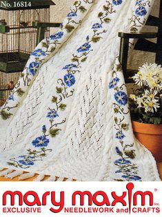 an advertisement for mary moxim's needlework and crafts, featuring a blue flowered afghan