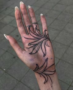 a person's hand with a flower tattoo on the middle of their left palm