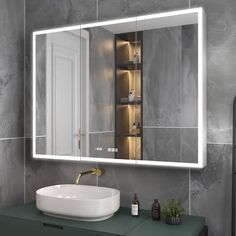 a bathroom with a sink, mirror and lights on the wall above it's counter