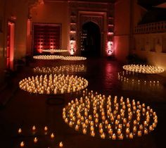 many lit candles are arranged on the floor