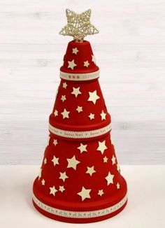 a red christmas tree with white stars on it and a gold star atop the top