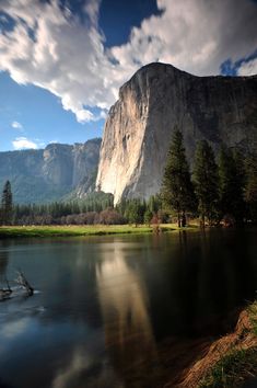 an image of a mountain that is in the distance with water and trees around it