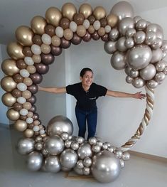 a woman standing in front of a giant balloon arch