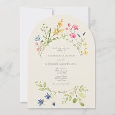 a wedding card with watercolor flowers and leaves in the center on a white background