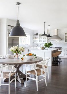 a kitchen with white cabinets and an island in the center, surrounded by wooden flooring