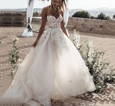 a woman in a wedding dress is walking down the aisle with her hand on her hip