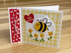 a close up of a card with a bee on it and a heart in the middle