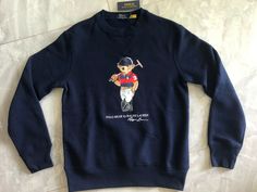 NWT Polo Ralph Lauren Men Polo Bear Fleece Sweatshirt  The iconic Polo Bear is ready to play his namesake sport on this cotton-blend hoodie. His uniform is meticulously detailed from his Polo Ralph Lauren Stirrup watch down to the signature Pony on his Polo shirt. Long Sleeves Crew Neck Fleece Sweatshirt V-Inset Ribbed cuffs and ribbed hem Iconic Polo Bear wears Striped Rugby "Polo Bear by Ralph Lauren" and "Ralph Lauren" script printed at the center front Color:  Cruise Navy Size: 2XL Measureme Vintage Ralph Lauren Sweater, Polo Bear By Ralph Lauren, Preppy Brands, Polo Ralph Lauren Sweater, Rugby Polo, White Turtleneck, Polo Bear, Ralph Lauren Sweater, Navy Sweaters