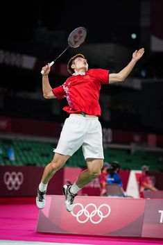 a man jumping in the air with a tennis racket