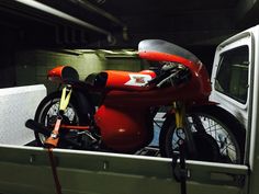 a red motorcycle is parked in the back of a truck