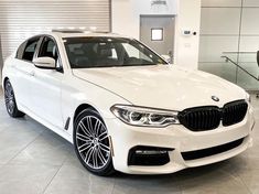 a white car is parked in a showroom