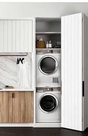 a washer and dryer in a room with white walls, wood cabinets and marble counter tops