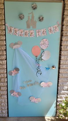 a blue door decorated with pink and silver decorations for a princess birthday party or baby's first birthday