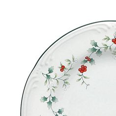 a white plate with holly and red berries on the rim is shown against a white background