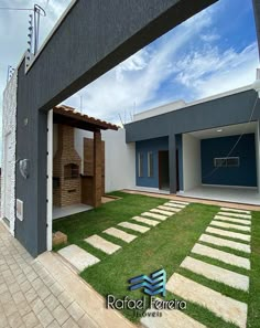 a modern house with grass and stone walkways