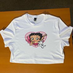 New Without Tags! This Item Is A Really Cute Graphic Tee Of Betty Boop And Her Dog, It Is Unbranded. The Size Is 3xl, But If You Have A Larger Chest This Might Fit Too Short. It Is Very Stretchy. This Top Is 19 Inches Across The Chest And 17 1/2 Inches Long. Feel Free To Message Me For More Info :) Trendy White Cartoon Print Top, Trendy White Top With Cartoon Print, Trendy White Tops With Cartoon Print, White Cotton Tops With Cartoon Print, White Graphic Tee With Cartoon Print, White Cartoon Print Graphic Tee, White Relaxed Fit Top With Cartoon Print, White Cotton Crop Top Shirt, Cute White Tops For Streetwear