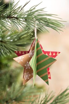 an ornament hanging from a christmas tree decorated with red, green and gold stars