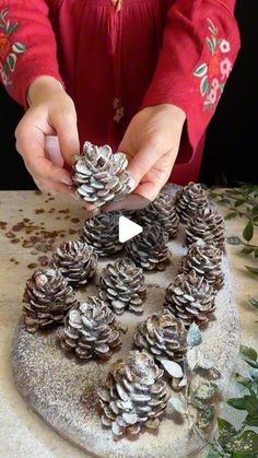 a person cutting up pine cones on top of a table