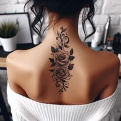 the back of a woman's neck with a rose tattoo on her left shoulder