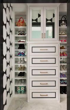 an organized closet with black and white wallpaper