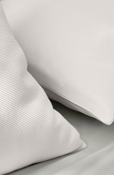 two white pillows sitting next to each other on a bed