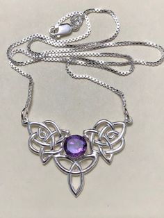 An elegant finish to a popular Celtic knot design and a wonderful gift for her, or yourself, with this simple and elegant boho chic necklace! A Valentine's Day gift, birthday or any special occasion! This piece is fabricated in sterling silver and features a 6mm center faceted gemstone set within the center of the Celtic knot in a 4 prong setting. Also, this comes with an 18 inch sterling silver box chain, 1mm in thickness. The total length of the pendant is 1 inch for a total of 18 inches inclu Silver Mystical Necklace With Cabochon, Celtic Emerald Necklace, Nickel-free Amethyst Bohemian Jewelry, Ornate Amethyst Pendant Necklace, Nickel-free Amethyst Crystal Necklaces For Gift, Boho Chic Necklace, Celtic Knot Designs, Blue Topaz Necklace, Topaz Necklace