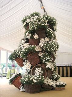 several baskets are stacked on top of each other with flowers growing out of the tops