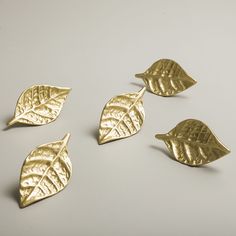 four gold leaf charms sitting on top of a table