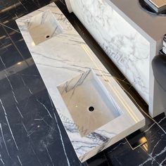 a bathroom with marble counter tops and black flooring