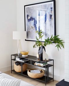 a black and white living room with art on the wall, plants in vases and other decorative items