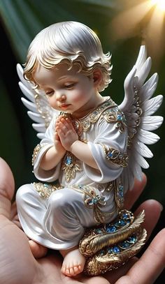 a small angel statue sitting on top of someone's hand