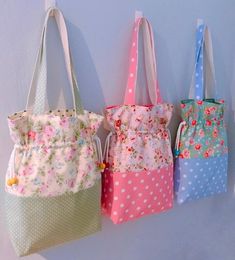 three purses hanging on the wall with polka dots and flowery fabric bags attached to them