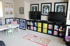 a living room filled with lots of furniture and pictures on the wall next to a flat screen tv