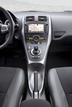 the interior of a car with steering wheel and dash board, dashboard, and navigation system