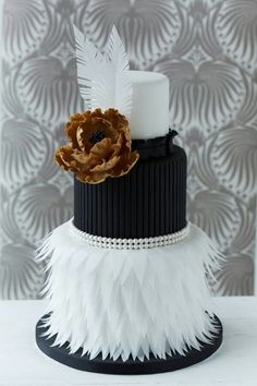 a wedding cake with feathers on it and a flower in the middle is featured for an article