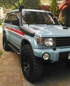 a light blue suv parked in front of a house