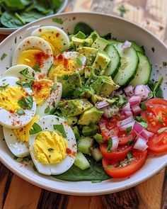 a salad with hard boiled eggs, tomatoes and cucumbers in a white bowl