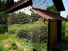 a building made out of metal pipes in the middle of some grass and trees with lots of circles on it