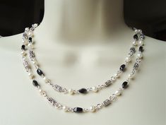 "You really can't go wrong with this classic black and white necklace. It is so elegant and versatile, perfect for all seasons. This popular style necklace is very versatile and can be worn in three ways: simply as a long single-strand necklace, doubled to appear as a double-strand necklace, or hooked mid-way to appear like a lariat necklace (see images). This is a great piece to layer with other pieces. This dainty necklace combines beautiful small black onyx gemtones and white freshwater pearl Elegant Handmade Black And White Jewelry, Black And White Necklace, Large Bead Necklace, Black And White Necklaces, Gray Necklace, Long Statement Necklace, Double Strand Necklace, Onyx Jewelry, Black Onyx Stone