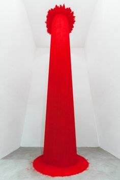 a tall red object in a white room