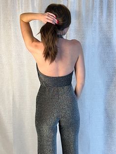 Take your holiday look to the next level this jumpsuit. Featuring a black material with a silver sequins, a cowl neck design and a flared fit, how could you resist? Pair with high heels and silver accessories to elevate the vibe! Metallic Sequined Jumpsuits And Rompers For Night Out, Fitted Disco Jumpsuits And Rompers For Evening, Disco Style Jumpsuits And Rompers For Party Season, Sleeveless Disco Jumpsuit For Night Out, Metallic Fitted Jumpsuits And Rompers For Party Season, Glamorous Metallic Jumpsuits And Rompers For Night Out, Glamorous Metallic Jumpsuit For Night Out, Glamorous Metallic Jumpsuits And Rompers With Sequins, Glamorous Fitted Jumpsuits And Rompers With Shimmer