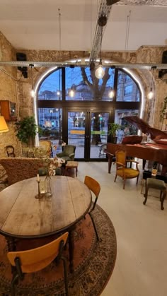 a room filled with lots of furniture and a piano in the middle of the room