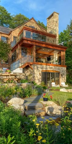 a large house surrounded by lush green trees and bushes with stone steps leading up to it